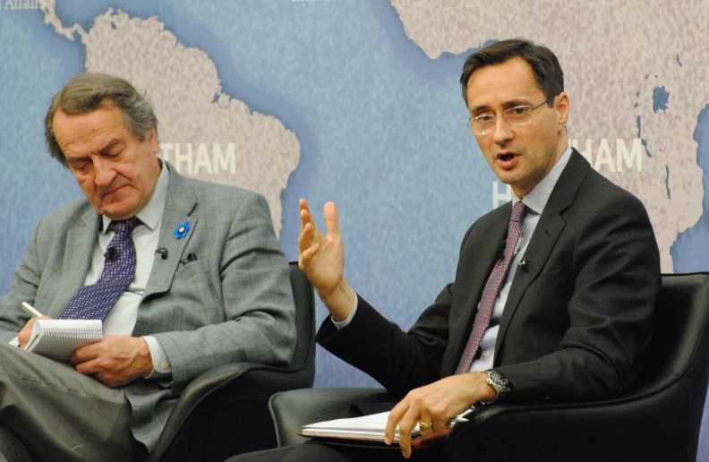 two men sitting side by side talking and having conversations