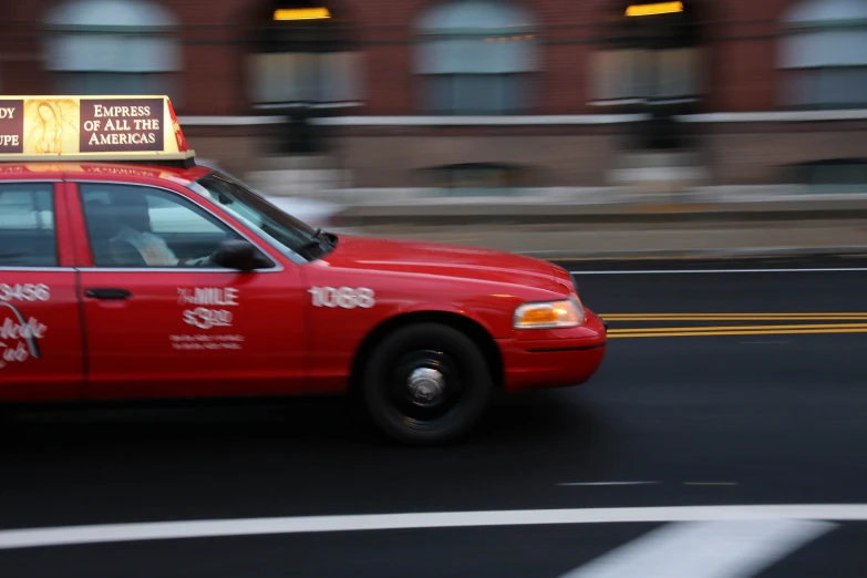 a red taxi with an advertit on the roof