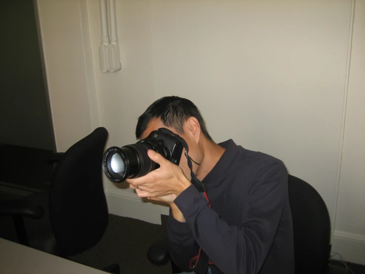 a man taking a po with his camera in an office