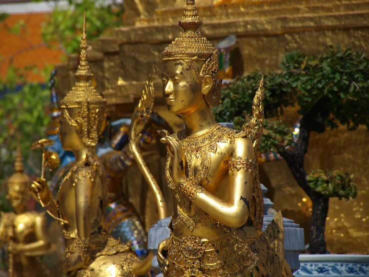 large golden statues are sitting near a building