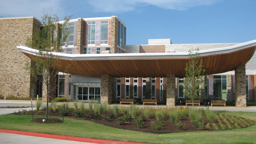 a building with wooden benches and a curved front lawn