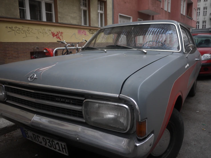 this car is parked on the street by buildings