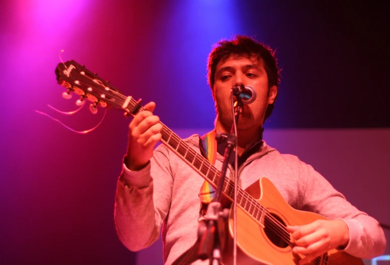 a man that is standing up with a guitar