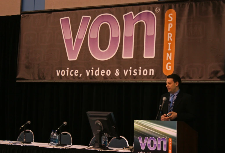 a man in a suit is speaking at a podium