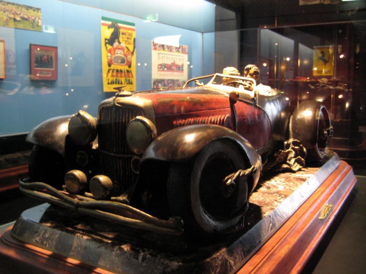 an old fashioned car displayed on a wooden table