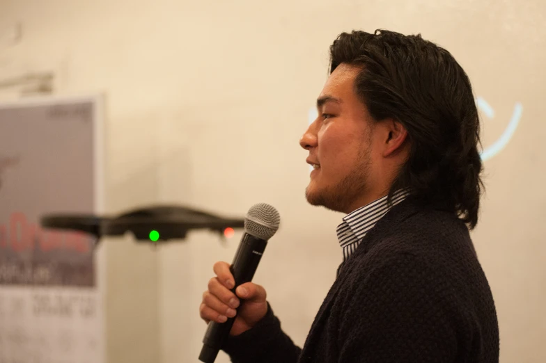 a man standing in front of a microphone next to a whiteboard