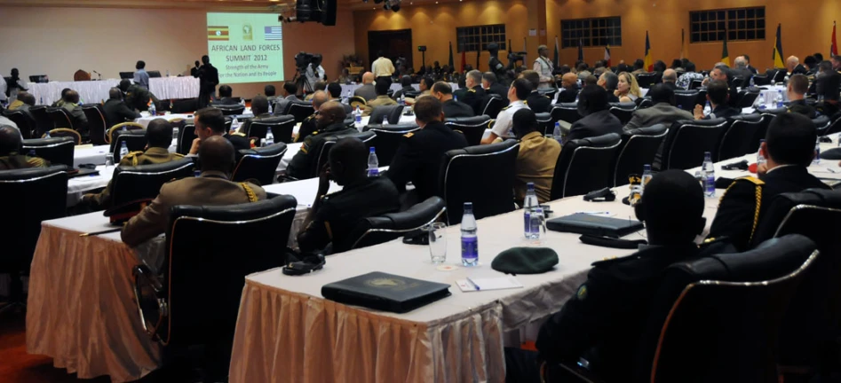 a room full of people seated at long tables during a presentation