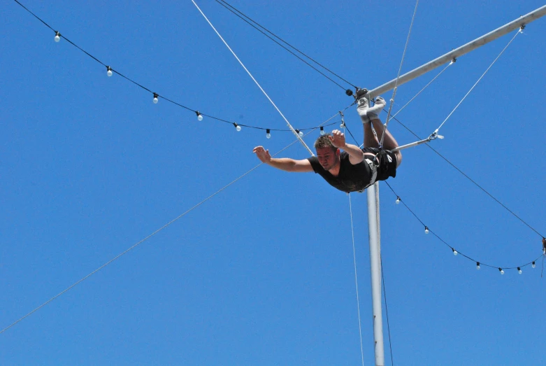 a person is in midair with an electric line behind him