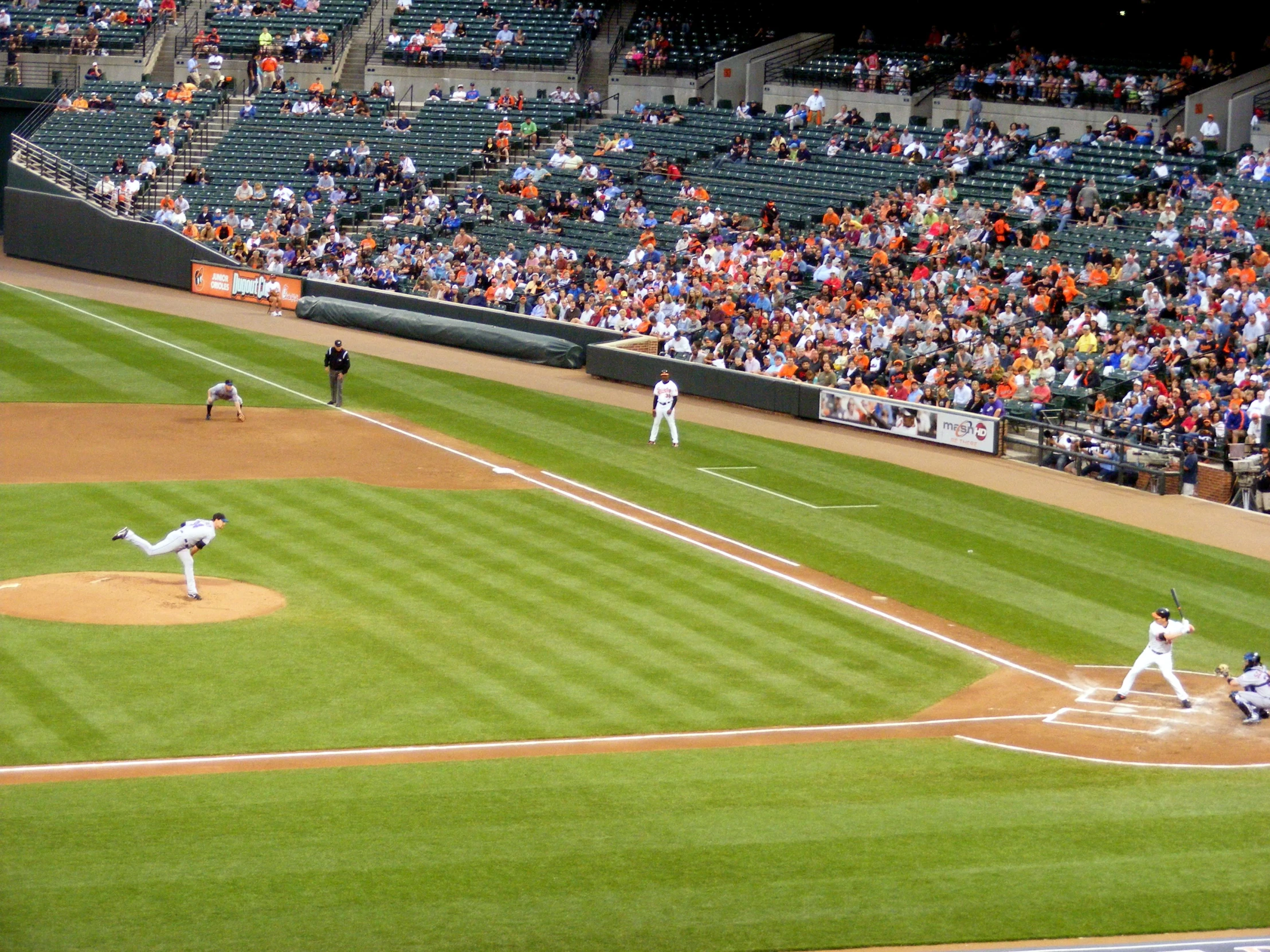 some baseball players playing baseball while many people watch