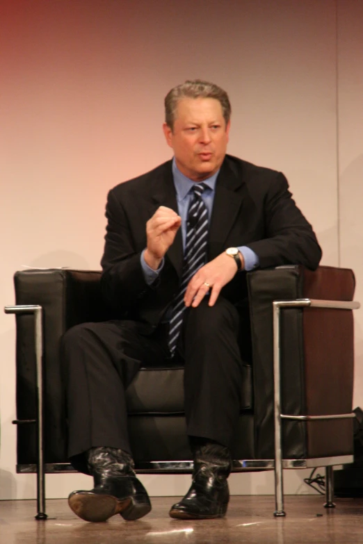 a man in business attire sitting on a chair