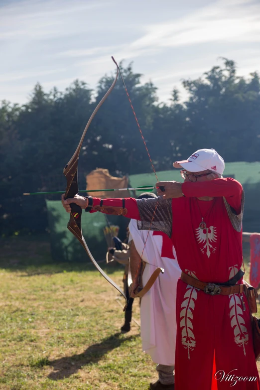 a man dressed in armor aiming with an arrow at a bow