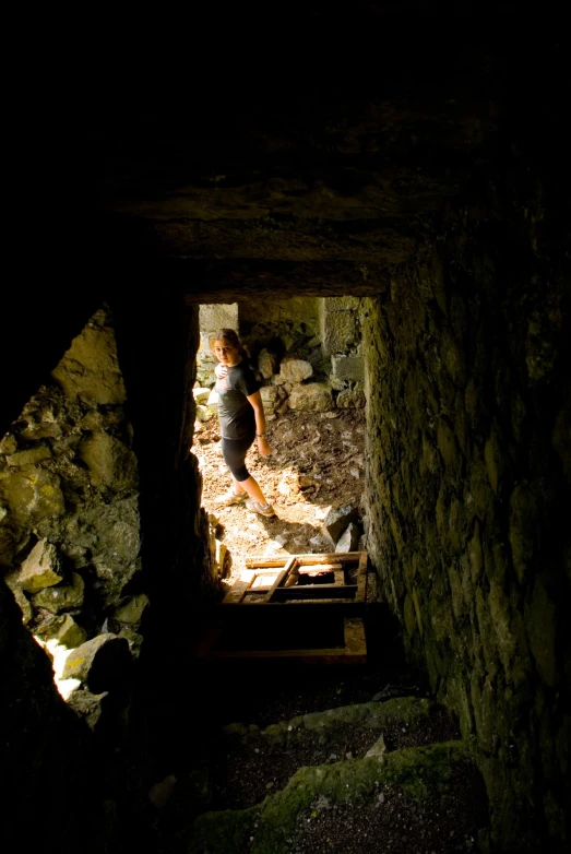 a person is standing in a cave with a door open