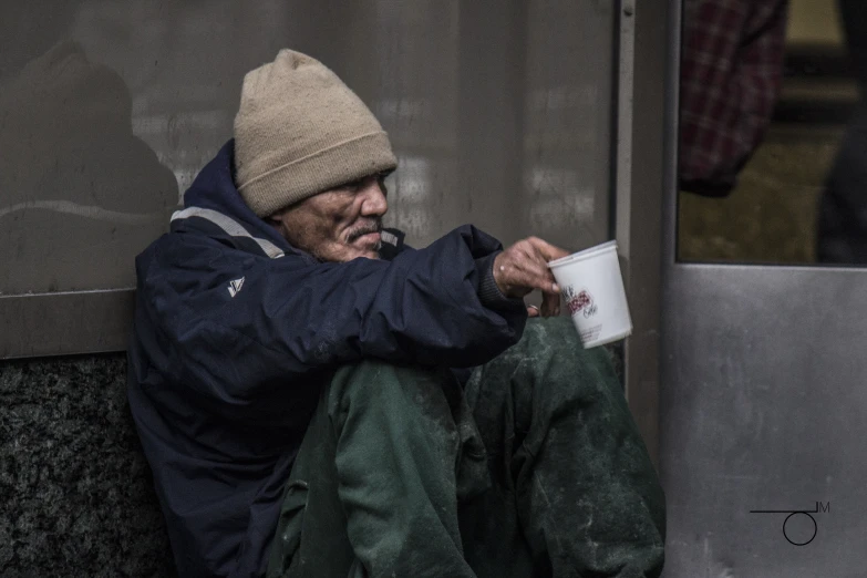 man in cold weather gear sitting on the ground