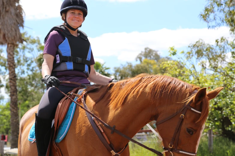 the girl in the helmet sits on the saddled horse