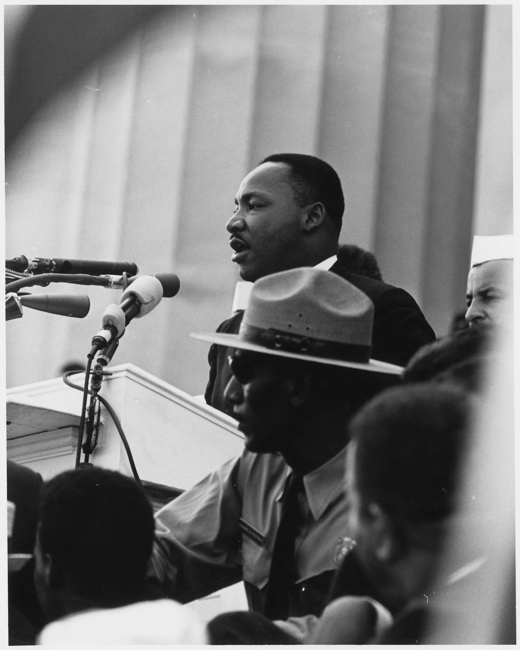 the black man speaks while standing in front of a microphone