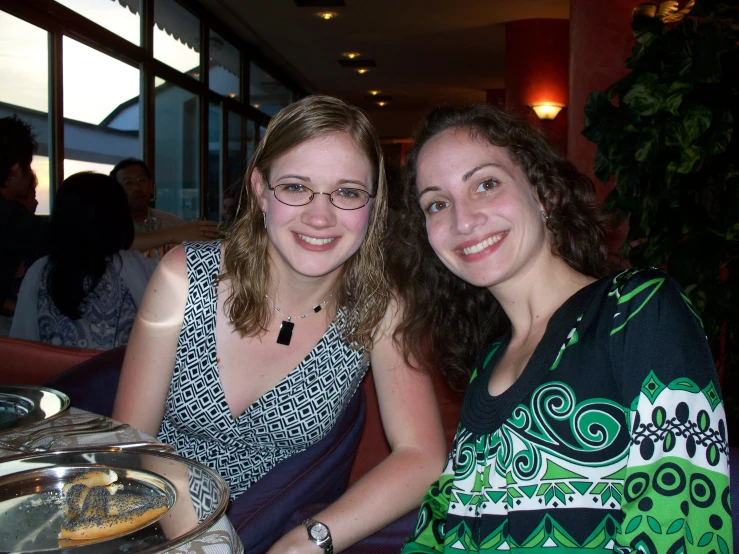 two women sitting next to each other at a table