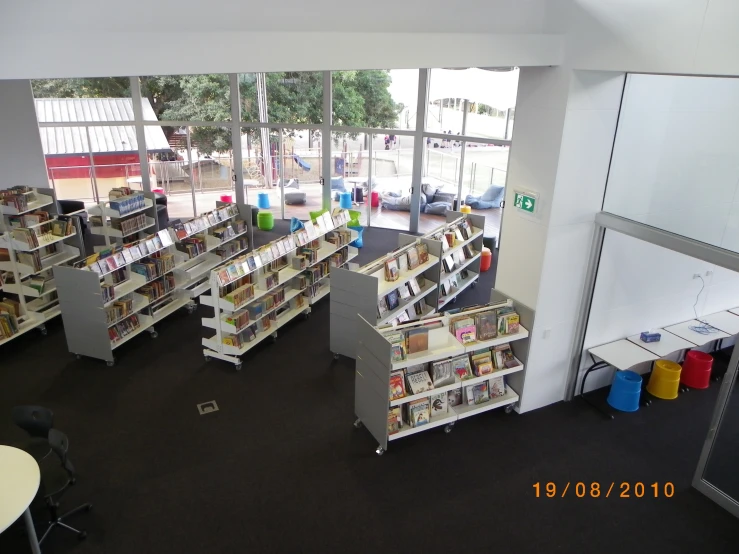 an indoor liry with large windows and various bookshelves