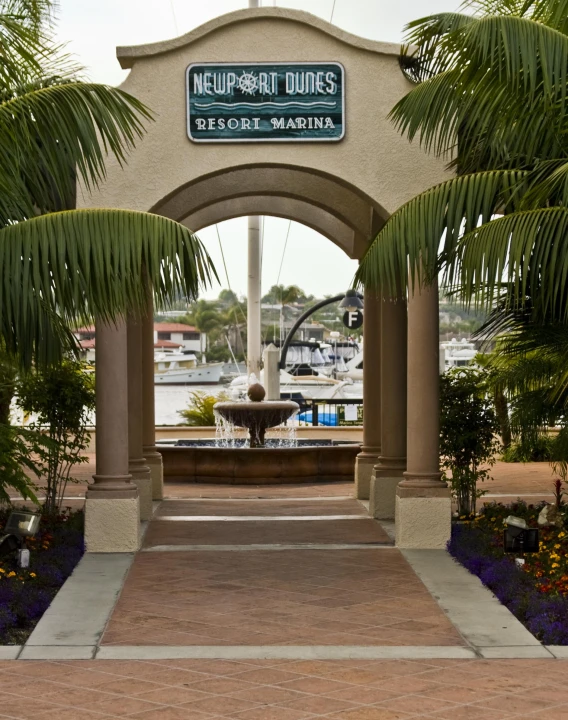 a water fountain is near an entrance to the marina