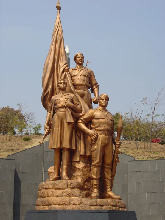 a statue of soldiers on display by a wall