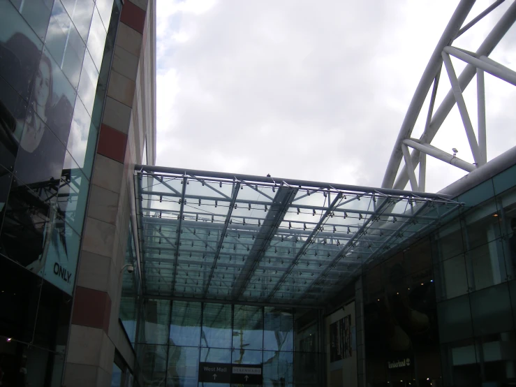 a walkway near two buildings has a lot of windows and is under the roof