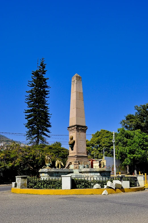 a large monument stands next to trees on a street