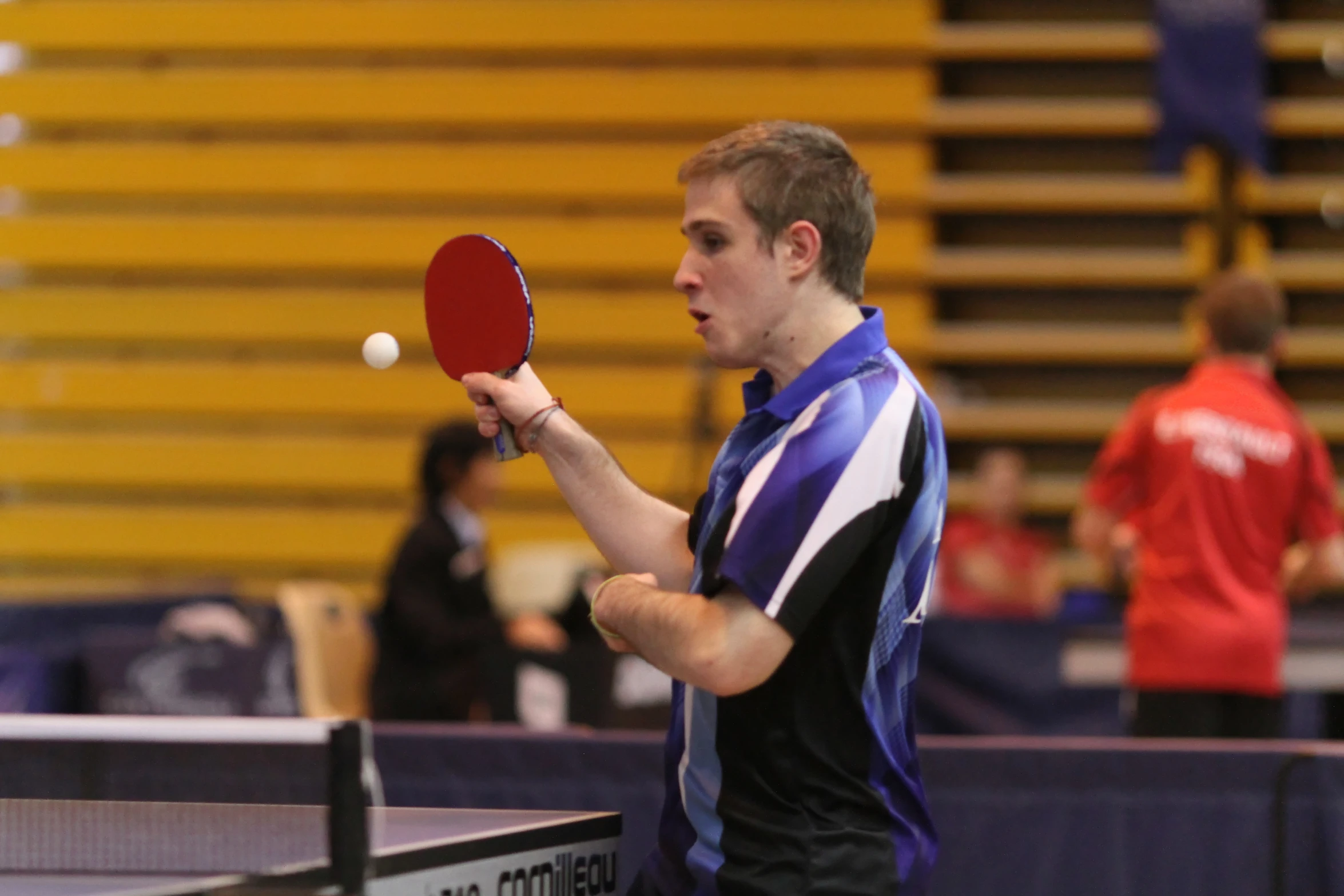 a man holding a racket playing table tennis