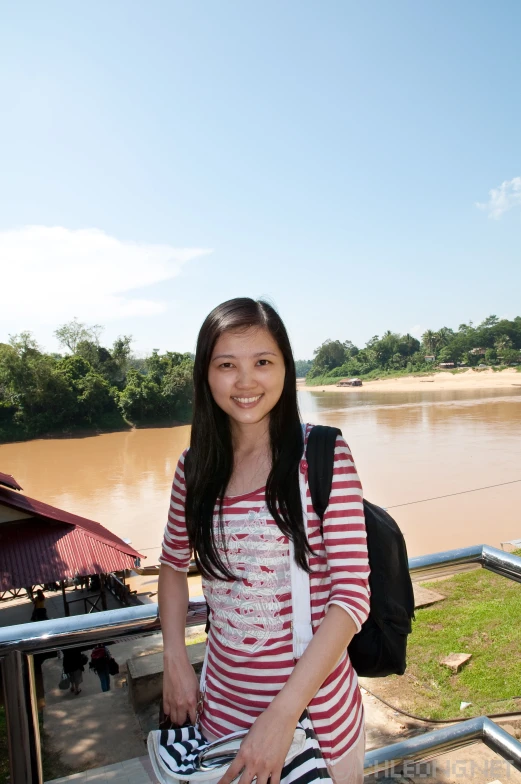 girl with backpack standing at the railing of an overlook