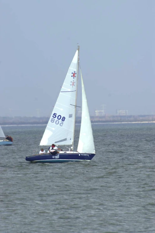 three small boats sailing in a open blue sea