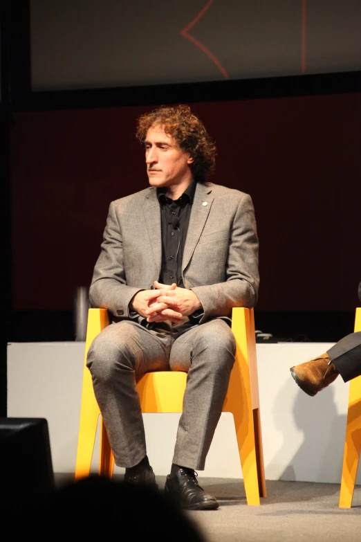 a person is sitting in a chair with other people behind him