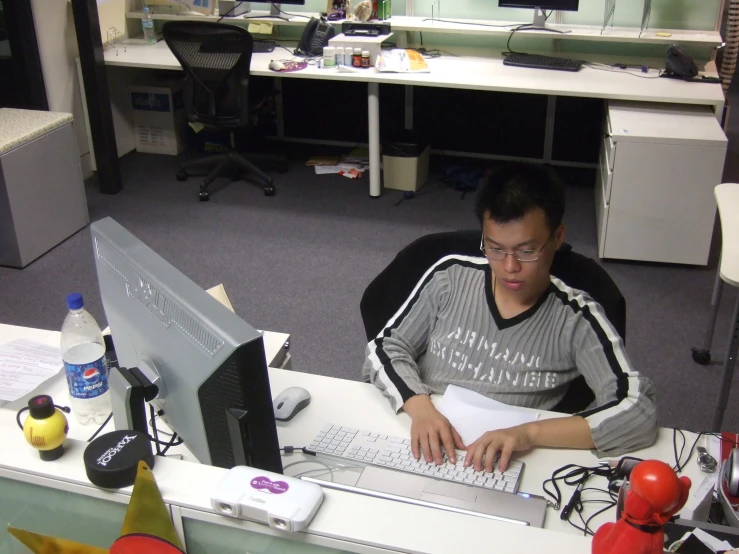 a man in the cubicle works on a computer