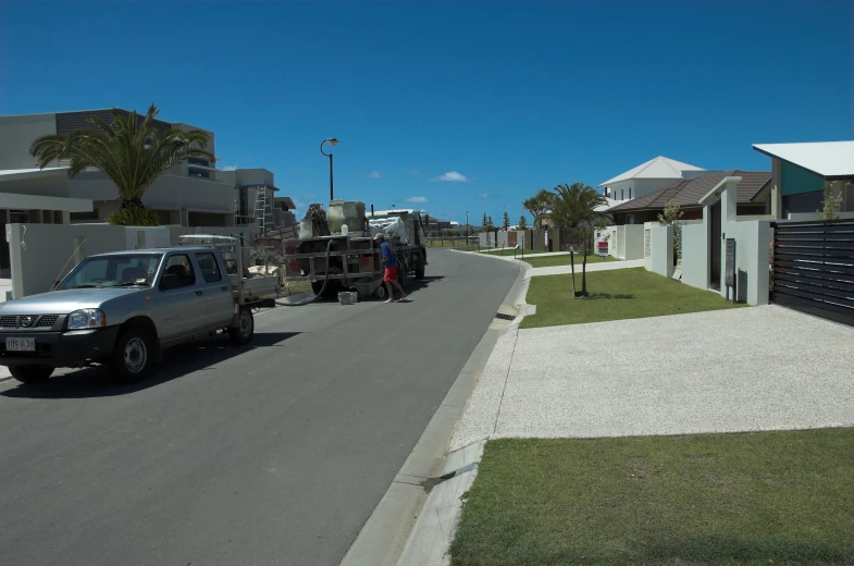 an utility truck hauling a house and landscaping supplies on the road