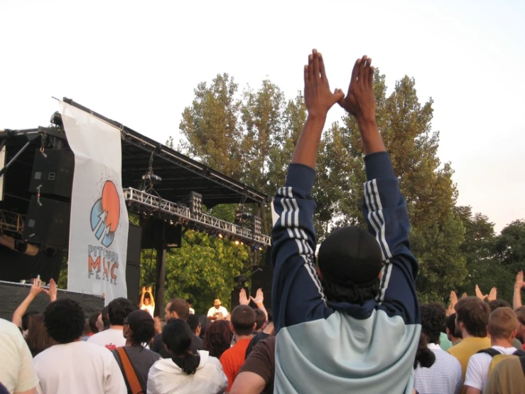 a person with his arms raised in front of a stage