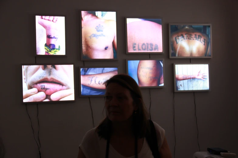 a woman looking up at wall with multiple images on it