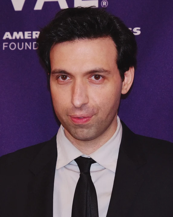 a close up of a person wearing a suit and tie