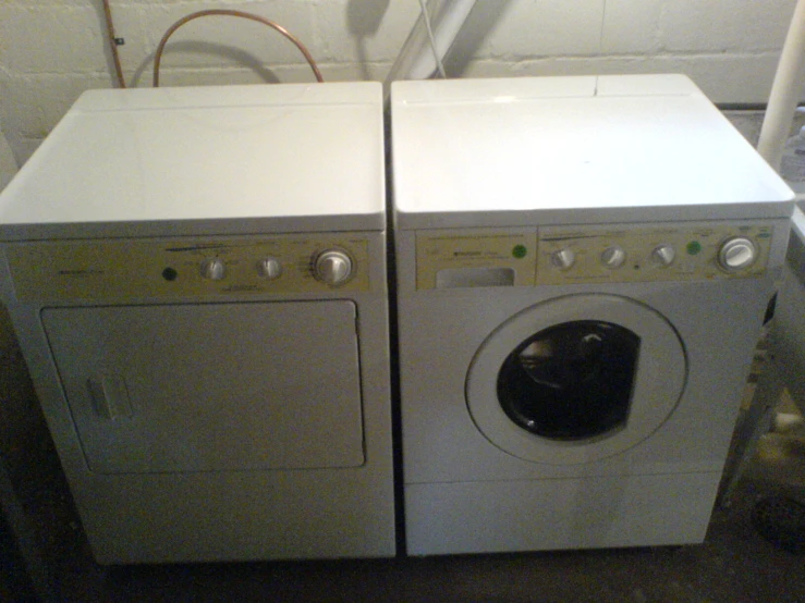 two washing machines sit on the floor near each other