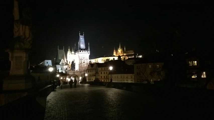 a building at night in a town with a clock tower in the background