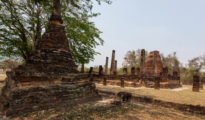 this is an image of a field with brick structures and trees