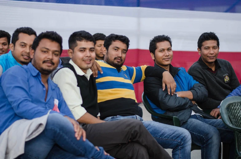 many men are sitting in rows together at a gathering