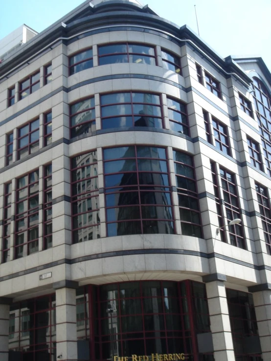 a large building with glass windows that has a clock on the top of it