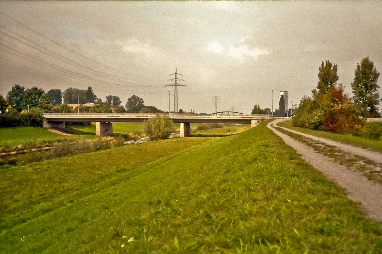 this bridge crosses over a wide river next to a lush green countryside