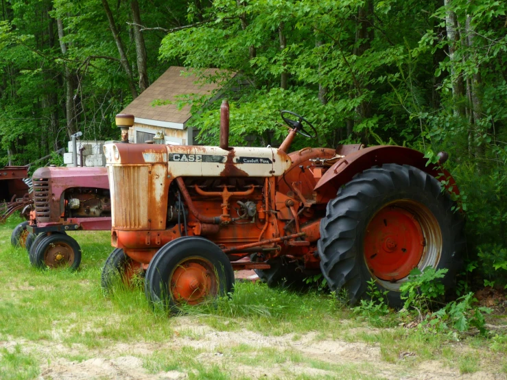 an old, rusty farm tractor parked in a field
