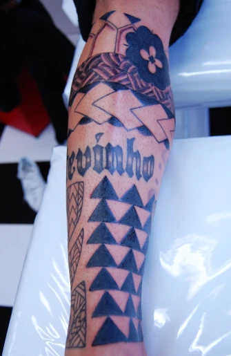 a man's leg with an armband and name tattoo on it