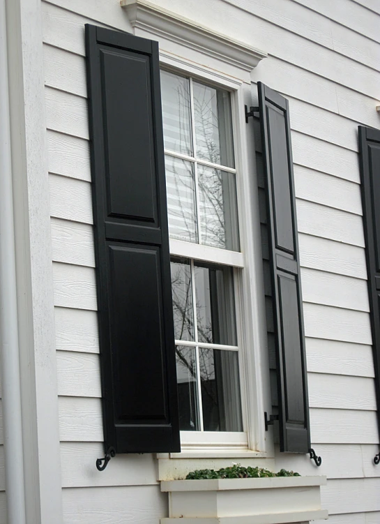 black shutters of an old white house window