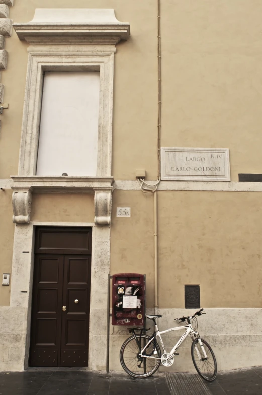 a bicycle leaning against the wall next to a tall building