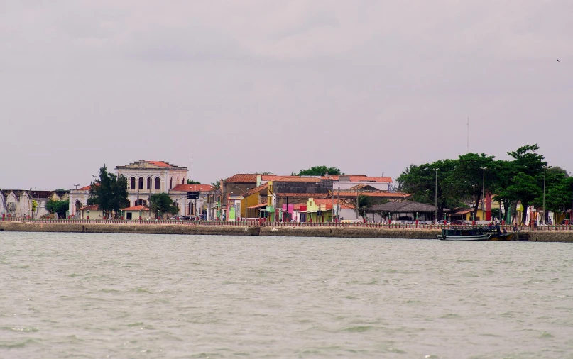 an island with a sail boat and buildings on top