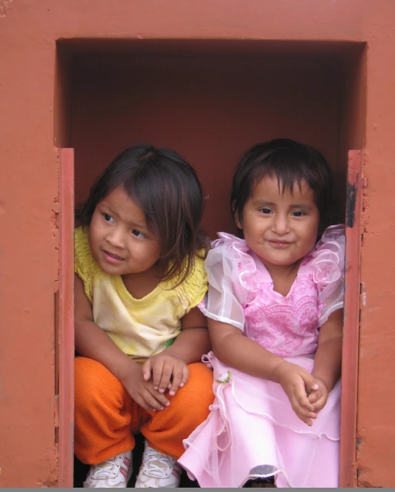 two young children are sitting on an open step