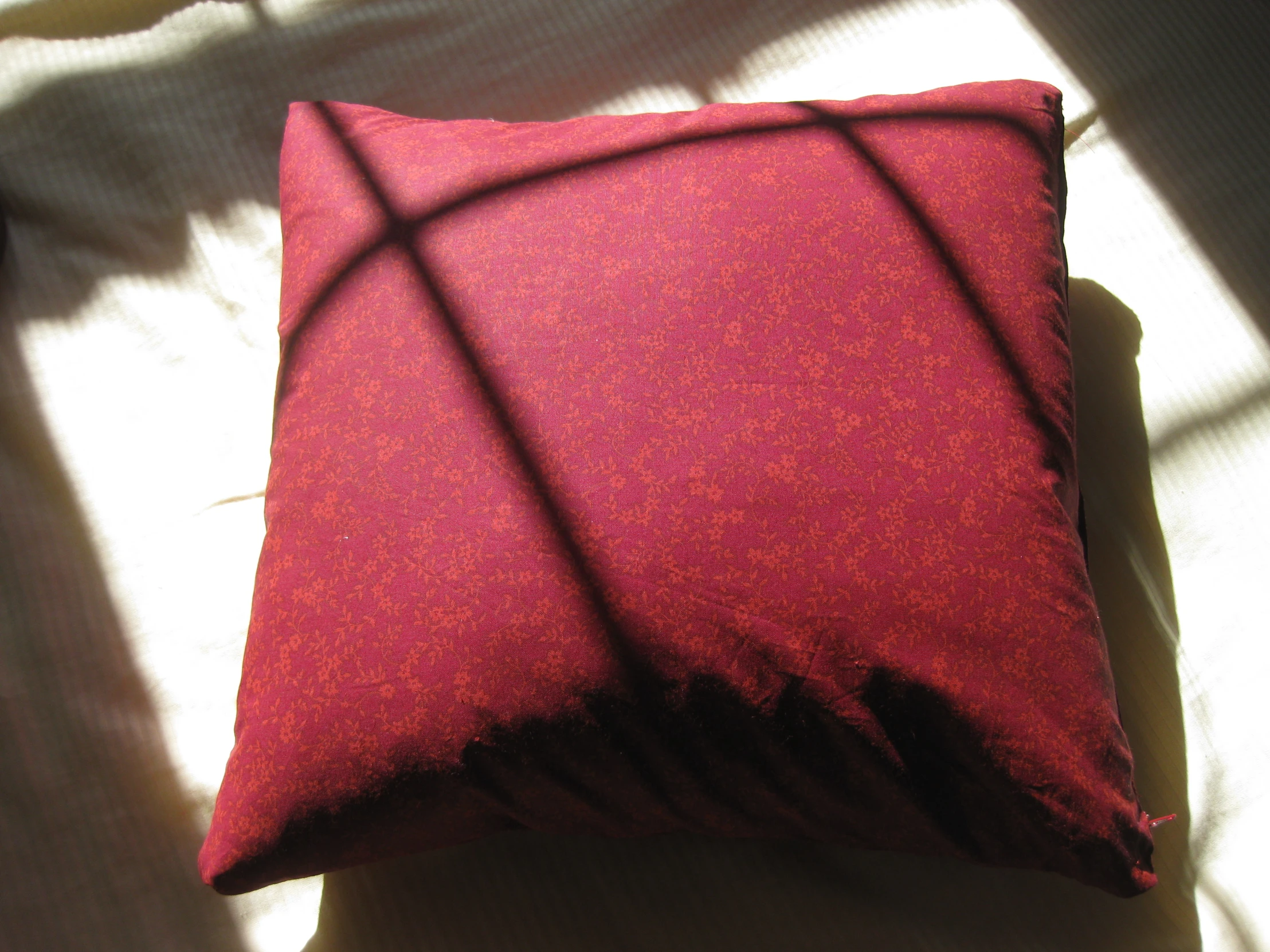 a pillow with the shadow of a cross made into it