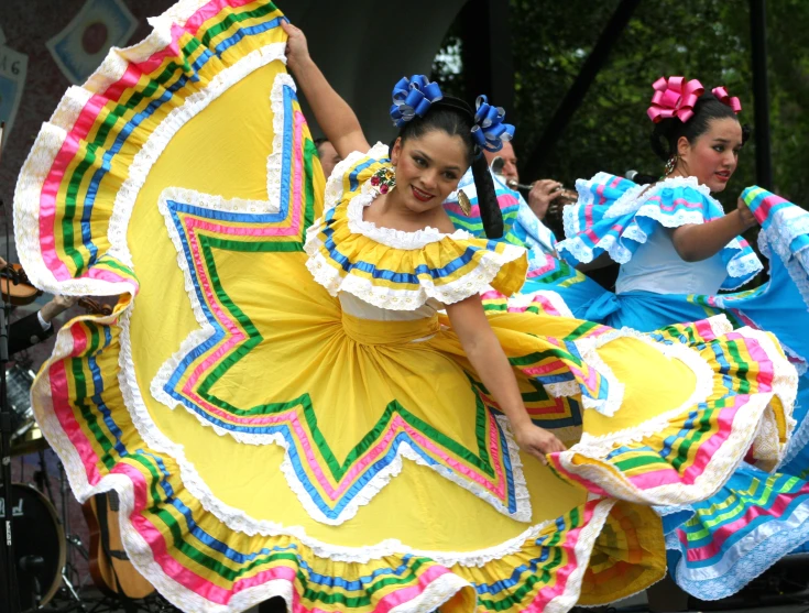 a woman in yellow and colorful dress dancing