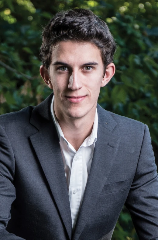 a man is sitting down and posing for the camera