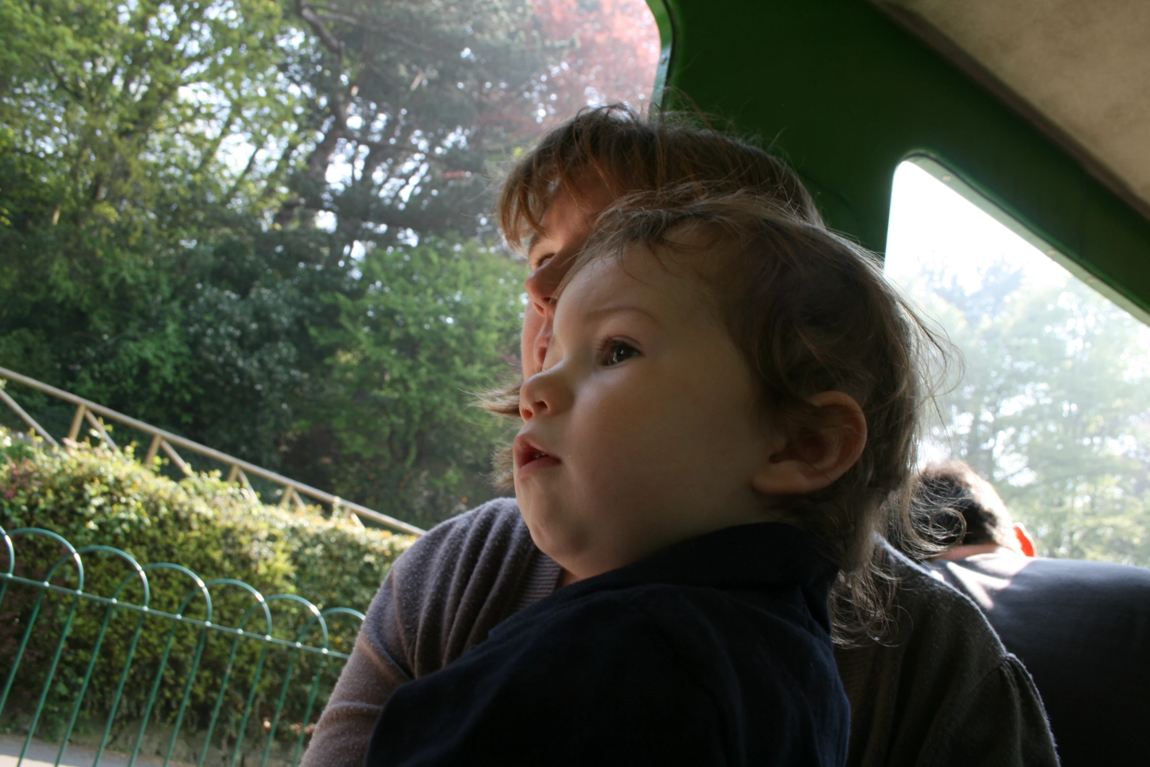 two young children on a bus, the child looks up